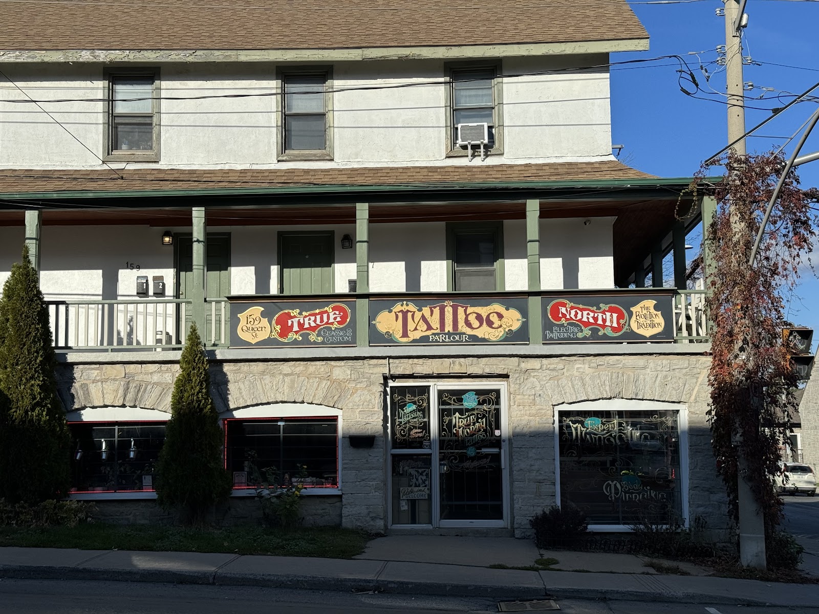 True North Tattoo storefront on Queen Street, stone and wood facade with red and gold signage